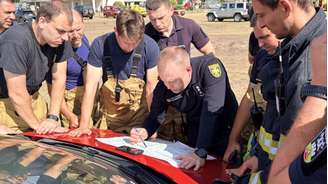 Briefing dos bombeiros ucranianos antes de uma intervenção em La Porge, departamento da Gironda, perto de Bordeaux, no sudoeste francês.