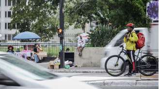 Entregador espera semáforo em ciclovia na Avenida Paulista