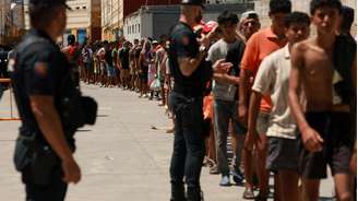 Migrantes fazem fila durante uma distribuição de alimentos em Ceuta, na Espanha, em 6 de agosto de 2026.