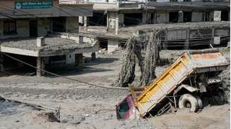 Casas e veículos danificados imersos na lama no dia seguinte às enchentes repentinas ao longo do rio Trishuli, no distrito de Nuwakot, no Nepal, em 26 de agosto de 2026.