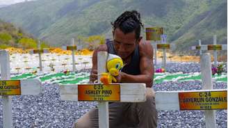 Com os olhos marejados, Javier Monteverde se ajoelhou diante da cruz que leva o nome de Ashley Pino, uma das mais de 6.500 vítimas do terremoto duplo que devastou a Venezuela.