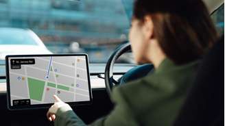 Mulher olhando para o GPS em um carro.