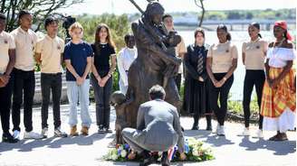 Imagem de arquivo. O ex-primeiro-ministro francês, Gabriel Attal (ao centro), deposita uma coroa de flores diante de uma estátua de Clarisse, uma mulher escravizada e enfermeira libertada em 1793, durante uma cerimônia em memória da abolição da escravidão em La Rochelle, no oeste da França, em 10 de maio de 2024.