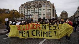 Manifestantes protestam contra a lei anti-ocupação em Paris, França, em 27 de novembro de 2022. Frase na faixa diz "ter onde morar não é um crime".