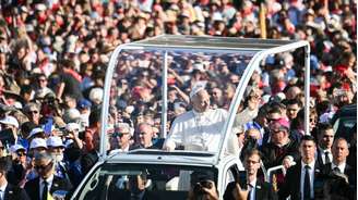 O papa Leão XIV cumprimenta fiéis ao chegar para celebrar uma missa na esplanada do Santuário de Nossa Senhora de Lourdes, no sudoeste da França, neste domingo (27).