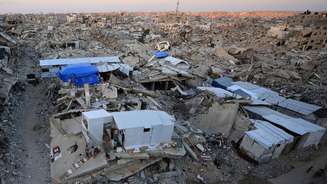 Palestinos montam barracas para viverem em meio aos escombros de prédios residenciais destruídos ao longo dos anos de ofensiva israelense, na cidade de Gaza. Foto de 22 de setembro de 2026.