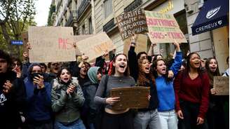 Manifestantes gritam slogans e seguram cartazes em uma rua durante um bloqueio à universidade Sciences Po, em Paris, como parte dos protestos estudantis em todo o país que exigem melhores condições nas instituições de ensino, França, 7 de outubro.