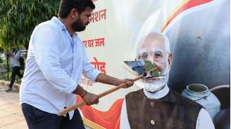 Manifestante rasga cartaz com a imagem do premiê Narendra Modi, em Nova Déli. (10/10/2026)
