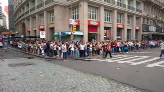 <p>Fila de passageiros à espera de lotação faz a curva na esquina em frente à prefeitura de Porto Alegre, onde um ato marca apoio à greve</p>