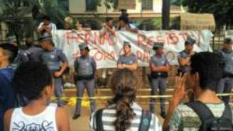 Colegas de classe de escola ocupada por estudantes em SP conversam, separados por cordão policial