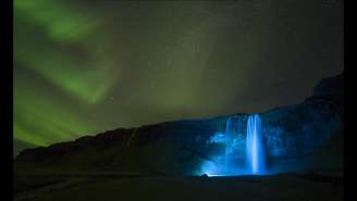Uma noite clara criou o ambiente para esta foto da aurora boreal sobre a gigantesca cachoeira de Seljalandsfoss, na Islândia. 