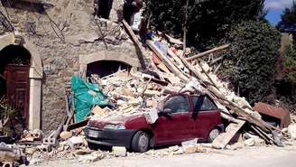 Carro é atingido por escombros após terremoto em Arquata del Tronto, na região central da Itália