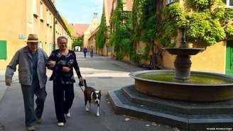 Vizinhos Ilona Barber e Friedrich Fischer passeiam em Fuggerei, na cidade alemã de Augsburg