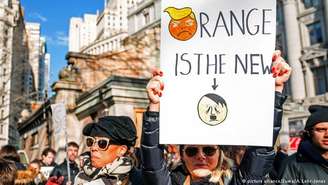 Em protesto em janeiro deste ano, manifestante em Nova York segura cartaz que compara Donald Trump a Adolf Hitler