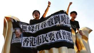 Pro-democracy activists chant slogans on the Golden Bauhinia Square, a gift from China at the 1997 handover, during a protest a day before Chinese President Xi Jinping is due to arrive for the celebrations, in Hong Kong, China 28 June 2017.