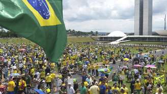 pessoas usando roubas amarelas em protesto em frente ao Congresso, em Brasília