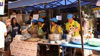 Voluntários e funcionários da cozinha real tailandesa preparam refeições para todos no acampamento da operação de resgate