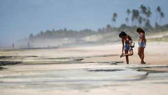 Banhistas em Conde, na Bahia; no Estado, órgão emitiu um alerta para que praias contaminadas com óleo sejam evitadas