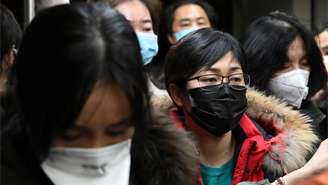 Passageiros usam máscaras de proteção ao desembarcar no aeroporto internacional de Pequim