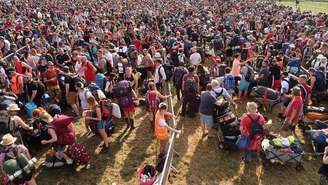 O público do Glastonbury aguarda pacientemente na fila para participar do festival de música