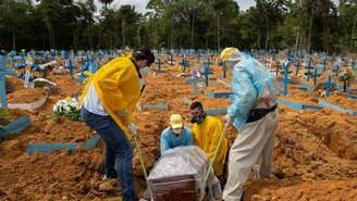 Homens enterram caixão em cemitério no Manaus