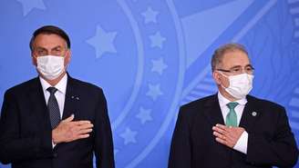 Jair Bolsonaro e Marcello Queiroga lado a lado com a mão no peito
