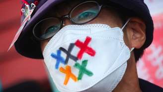 Homem com máscara em protesto contra os Jogos Olímpicos no Japão; medidas foram implementadas para tentar evitar que evento vire um 'superpropagador' de covid-19