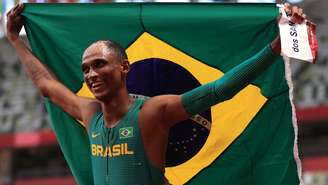 Alison dos Santos exibe a bandeira brasileira ao comemorar sua medalha de bronze