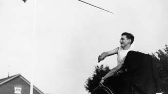 Ivor Elmes, um ex-policial palestino ferido em 1947, em sua cadeira de rodas enquanto lança um dardo nos Jogos de Stoke Mandeville, em 1953