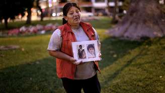 Rosa Rojas mostra foto do marido e do filho, mortos no massacre; menino tinha 8 anos de idade