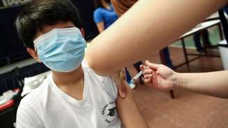 CoronaVac sendo aplicada em criança chilena; vacina foi liberada para uso em público de 6 a 17 anos no Brasil