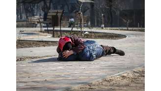 Dia 23/3 - Mãe protege seu filho durante bombardeio em Mariupol