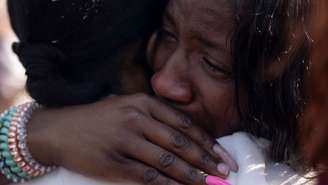 Mulheres se abraçam e choram durante vigília após tiroteio