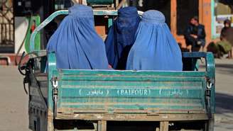 Mulheres vestidas com burca viajam em um veículo por uma rua da cidade de Kandahar em 18 de dezembro