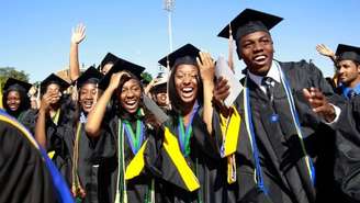 Imagem de formandos negros e negras com a beca para a formatura. Foto ilustra matéria sobre implementação das cotas raciais.