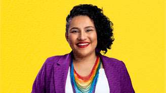 Deputada Vivi Reis aparece sorrindo com um colocar que estampa as cores da bandeira LGBTQUIA+