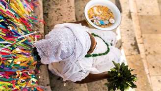 Imagem mostra mulher negra, adepta do candomblé, com vestes brancas.