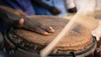 Imagem mostra um ogãn tocando atabaque.