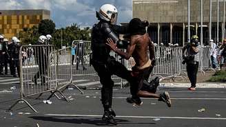 Imagem mostra manifestante negro sendo agredido por policial em manifestação contra o governo Temer, em 2017.