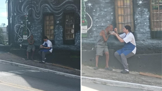 Funcionário do Restaurante Mocotó serve comida para pessoa em situação de vulnerabilidade
