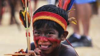 Imagem mostra menino indígena sorrindo.