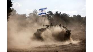 Um veículo blindado de transporte de pessoal israelense toma posição perto da fronteira com a Faixa de Gaza, no sul de Israel