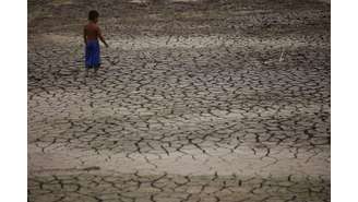 País enfrenta crise climática com queda de orçamento previsto para o Meio Ambiente. Em Manaus, um menino caminha pelas redondezas do Rio Negro, que atingiu sua maior seca em 121 anos