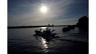 Um barco de pesca navega no porto de Hisanohama,