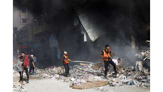 Bombeiros palestinos trabalham em prédio atacado por Israel em Khan Younis