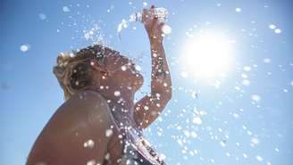 mulher jogando água na cabeça em dia de calor