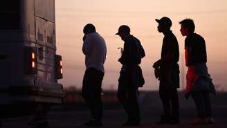 Fila de migrantes para entrar em ônibus no Arizona (EUA), depois de cruzarem a fronteira