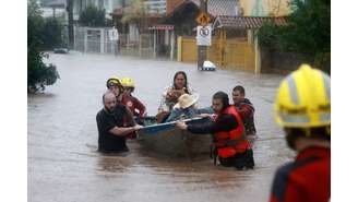 Socorristas resgatam família durante enchente em Porto Alegre, no Rio Grande do Sul