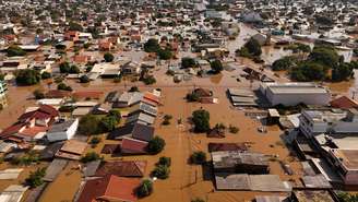 Imagem de drone mostra barco com voluntários buscando pessoas isoladas em casas em meio à enchente no bairro Mathias Velho em Canoas, Rio Grande do Sul (05/05/2024)