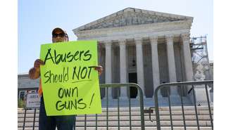 Homem segura carta contra posse de armas por condenados por violência doméstica em frente à Suprema Corte dos EUA